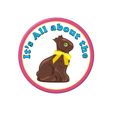 Metal buttons with the saying "It's All about the" followed by a chocolate bunny with a bite taken from the ears.