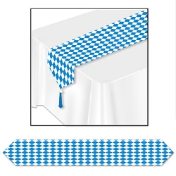 Table runner with white and blue diamond shape design and blue tassels on the ends.