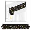Black table runner with silver and gold printed stars and each end adorned with a gold tassle. 